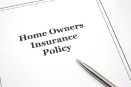 a homeowners insurance policy with a pen on top